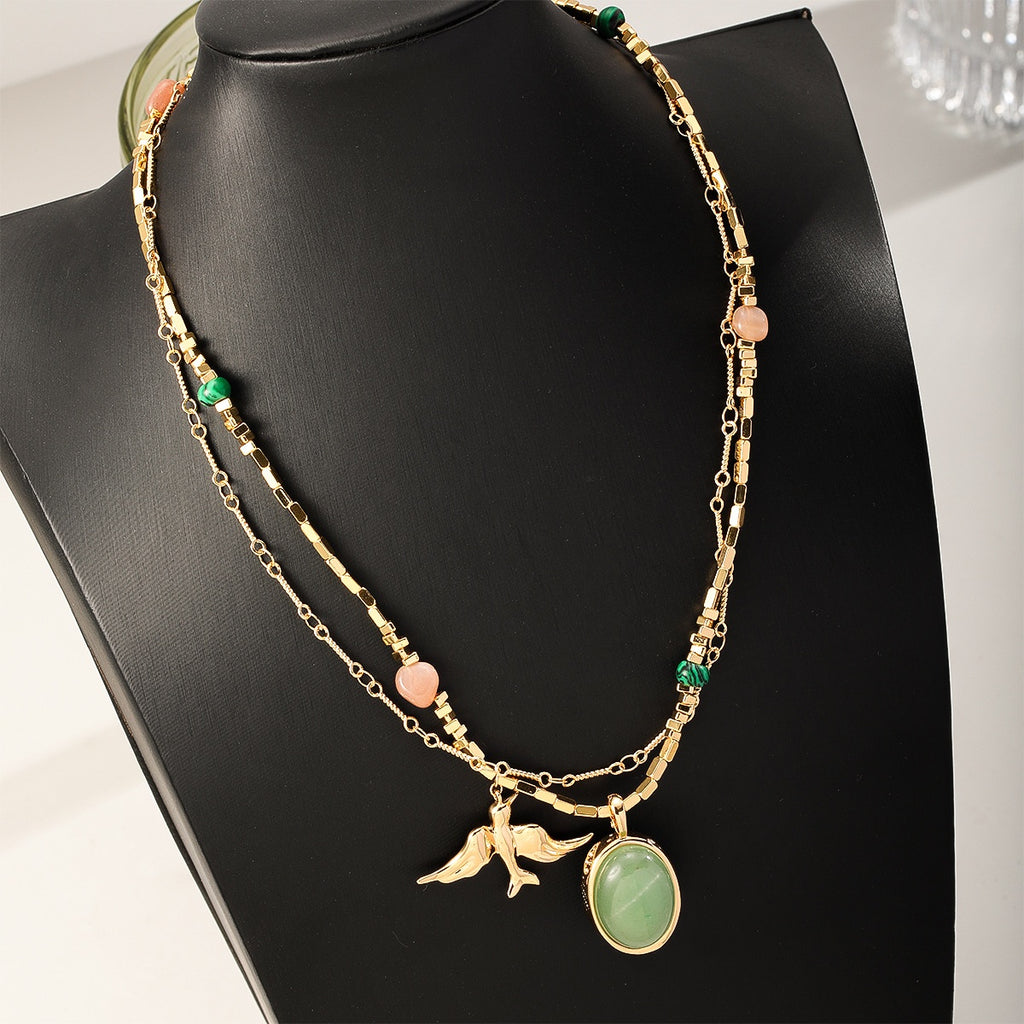 Gold Swallow Necklace — swallow and green stone, close up